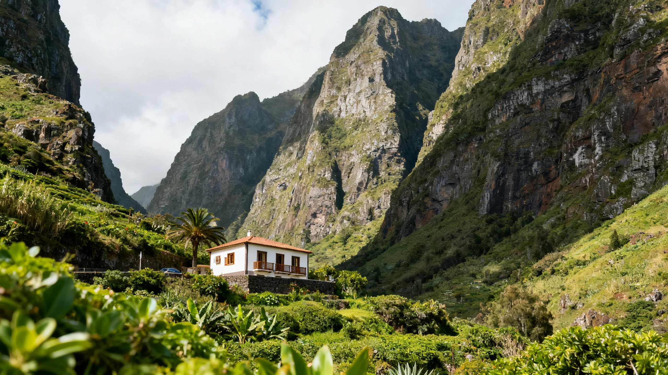 A small guesthouse in the green São Vicente valley with cliffs rising behind it
