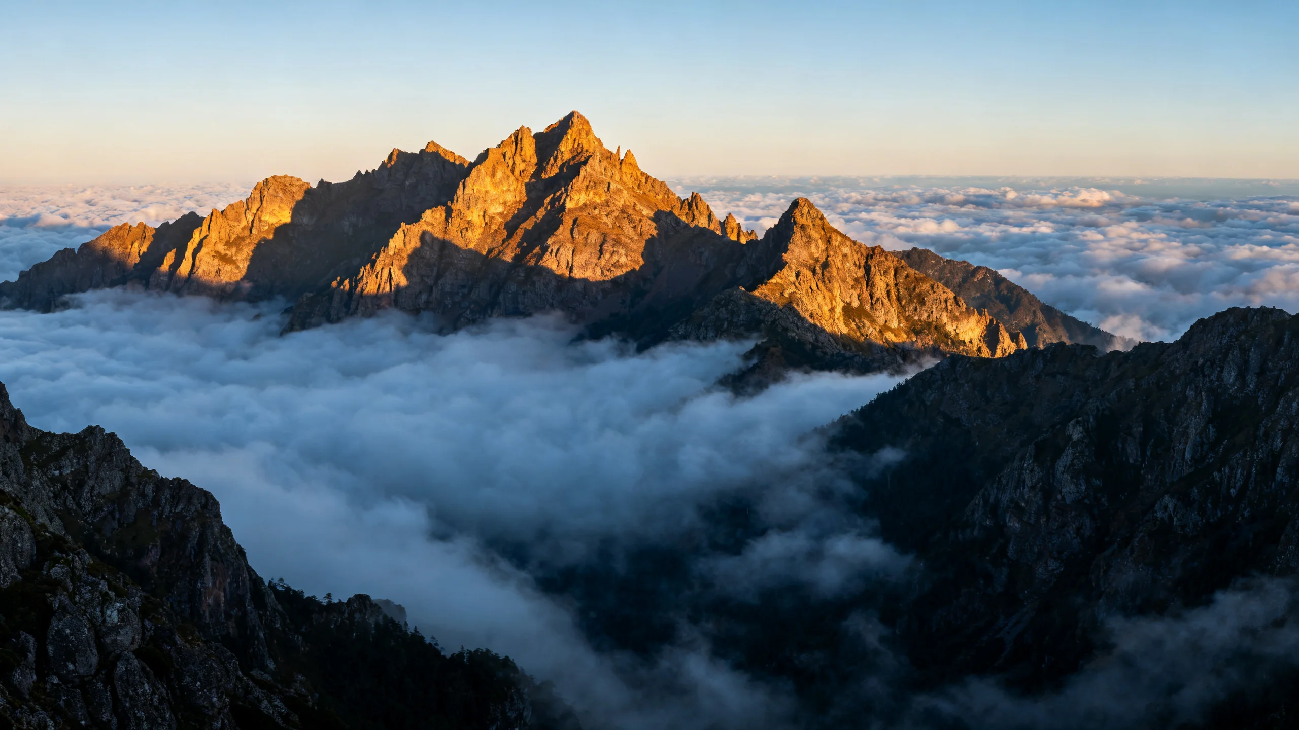 Sunrise light hitting the jagged peaks above Pico do Arieiro with a sea of cloud filling the valleys below